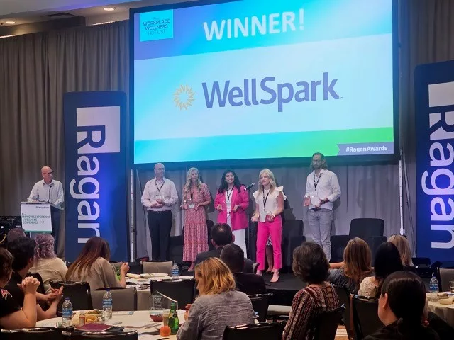 Image of WellSpark being recognized on stage at the Ragan Employee Experience and Wellness Conference